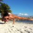 A woman doing a handstand on the beach.