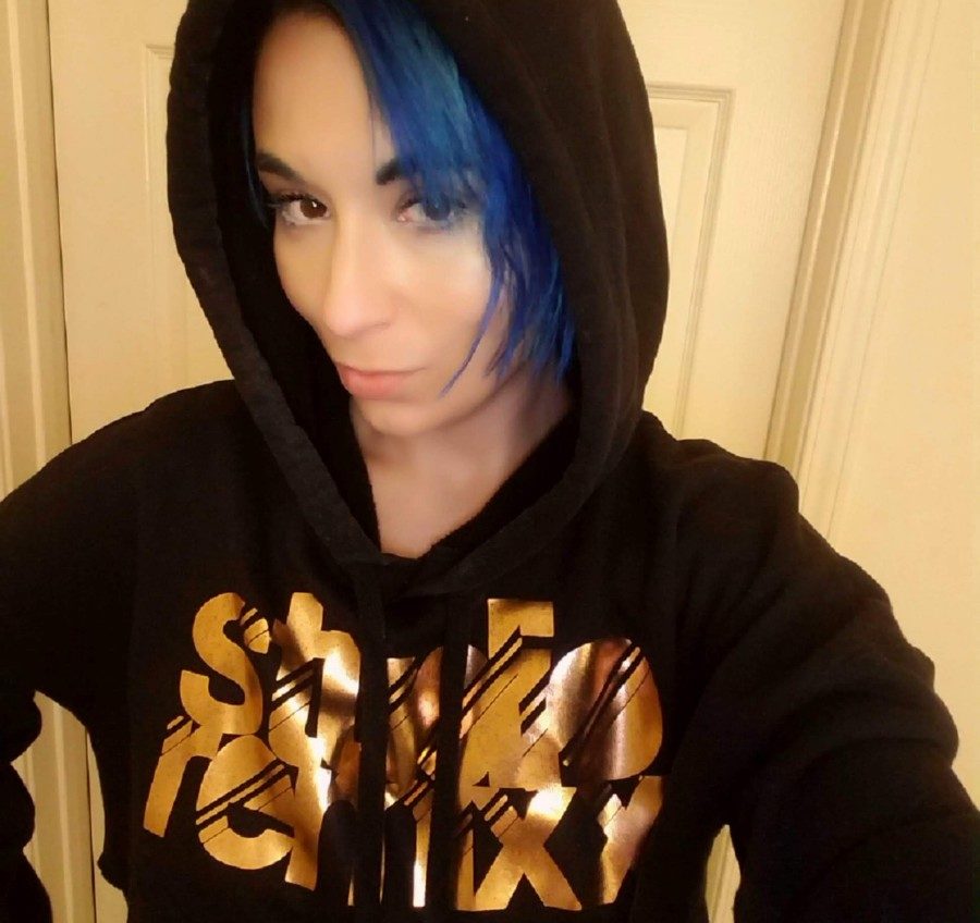 A woman with blue hair and a black hoodie.