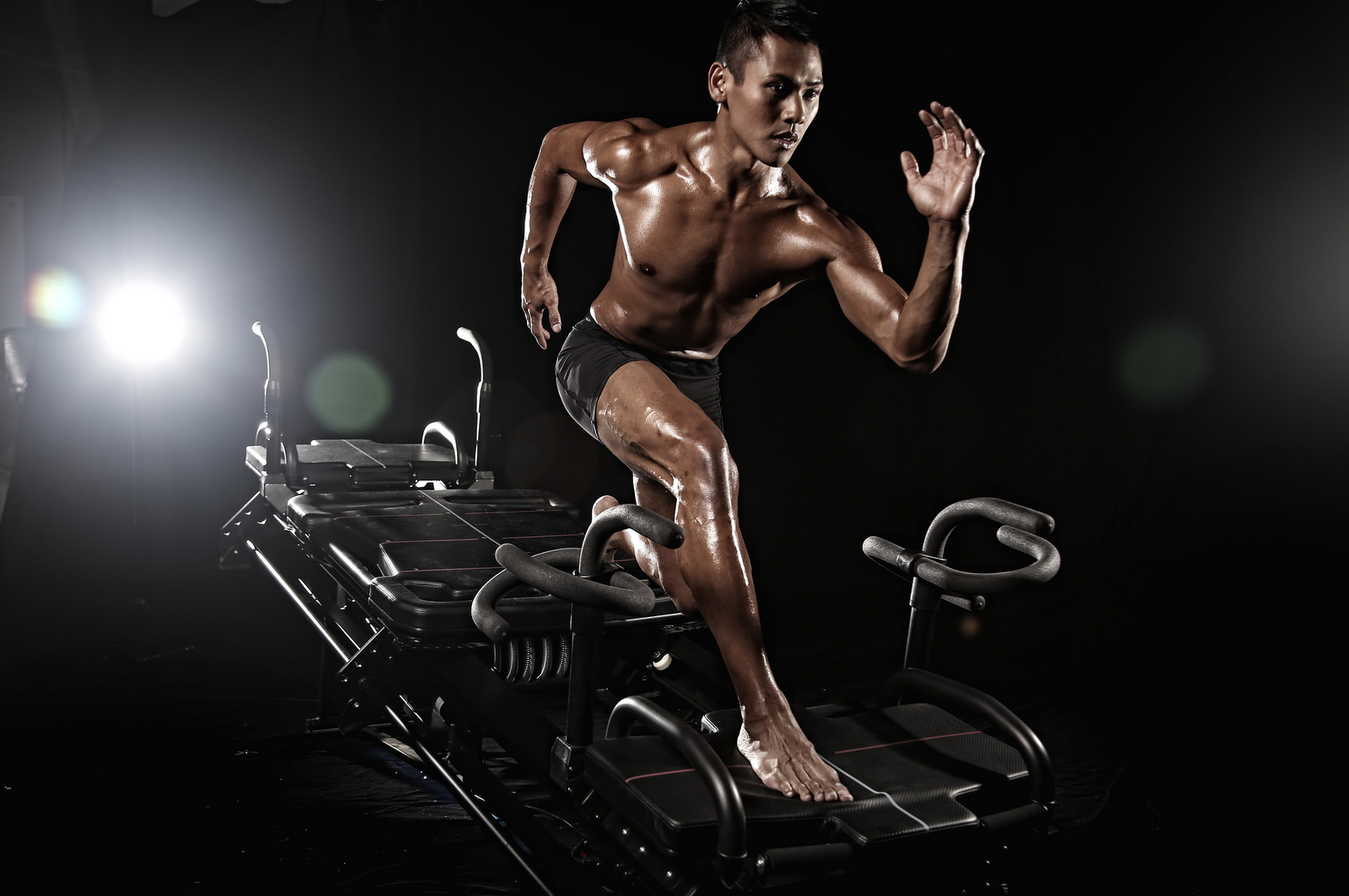 A man running on a treadmill in the dark.